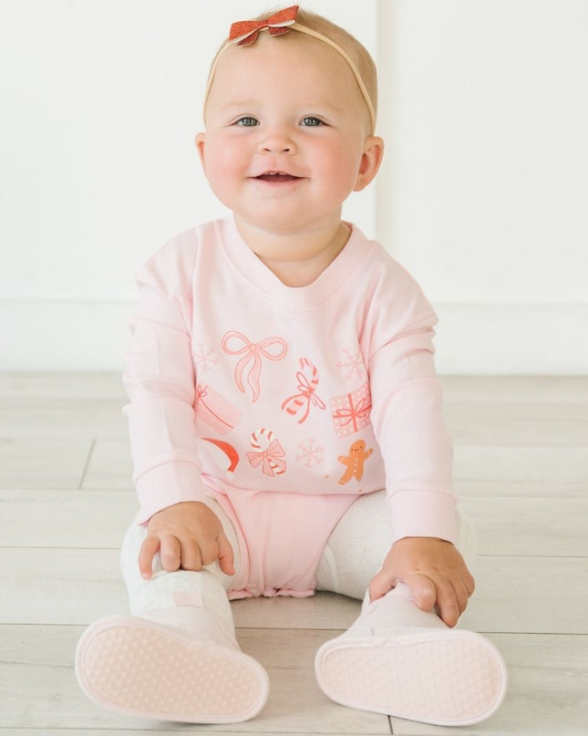 Baby wearing pink Romper with fun Christmas graphic