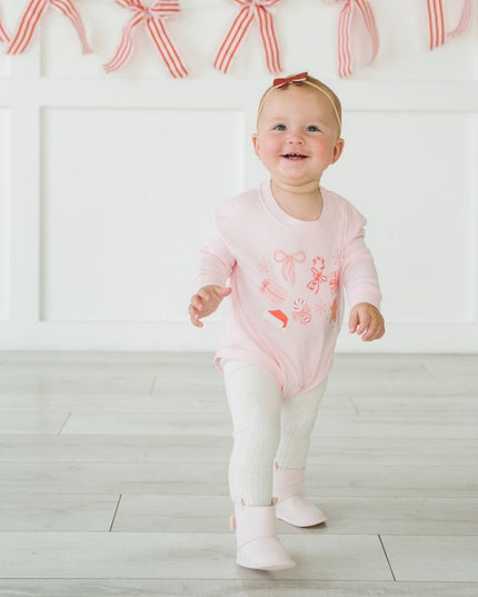 Baby wearing pink Romper with fun Christmas graphics