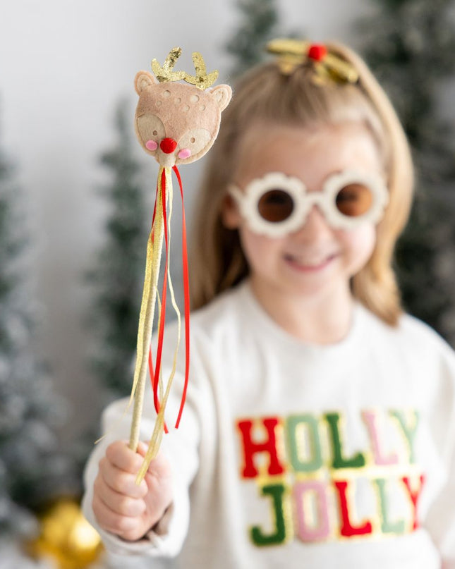 Girl holding gold and red reindeer wand