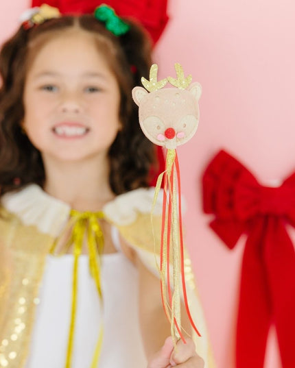 Girl holding gold and red reindeer wand