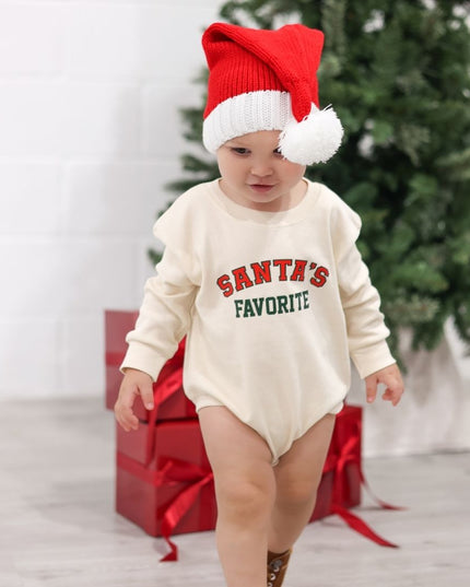 Baby wearing baby Romper with Santa's Favorite Graphic in Red and Green and Santa hat. 