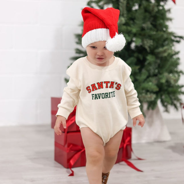 Baby wearing baby Romper with Santa's Favorite Graphic in Red and Green and Santa hat. 