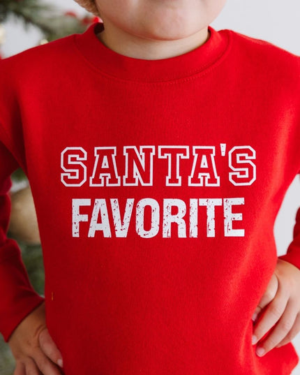 Boy wearing red sweatshirt with 'Santa's Favorite' graphic