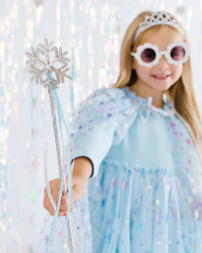 Girl wearing blue outfit and holding silver snowflake wand