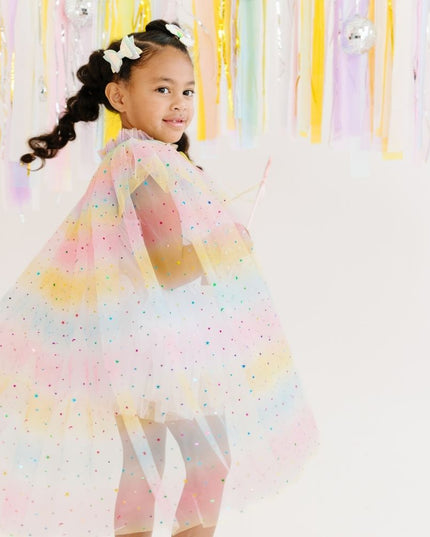 Girl wearing pink, yellow, and blue ombre tulle cape with rainbow star accents