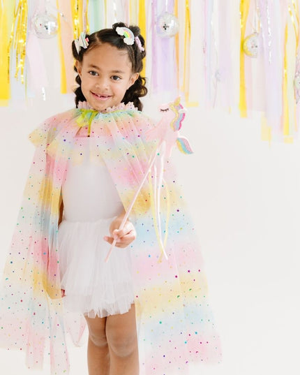 Girl wearing pink, yellow, and blue ombre tulle cape with rainbow star accents