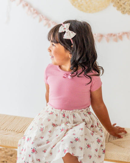 Girl wearing Tutu dress with mauve top and ivory coquette bow and floral tutu