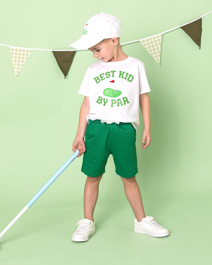 boy wearing white t-shirt that says best kid by par with golf flag graphic holding a golf club