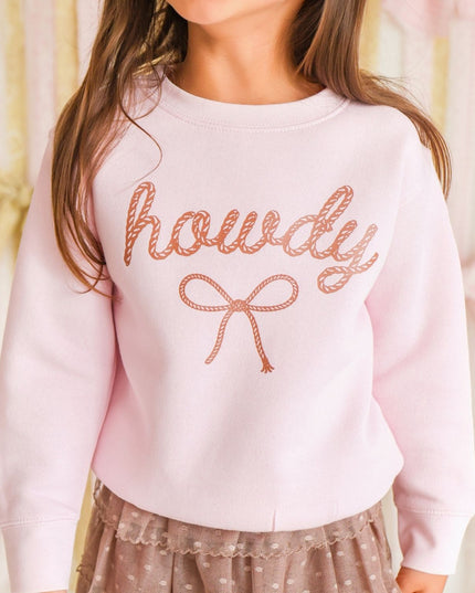 Girl wearing pink 'howdy' sweatshirt and brown skirt