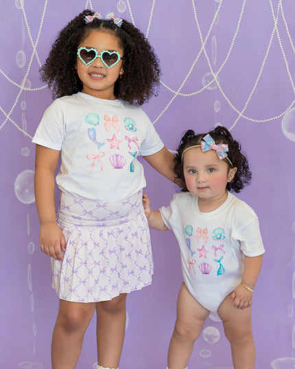 Girls wearing matching white mermaid graphic t-shirts
