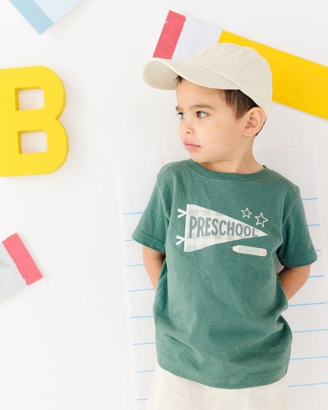 Boy wearing Green t-shirt with 'preschool' banner 