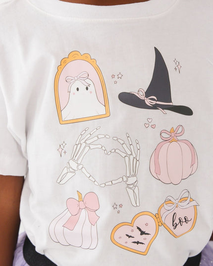 A girl wearing a white short-sleeve t-shirt with cute Halloween-themed graphics 