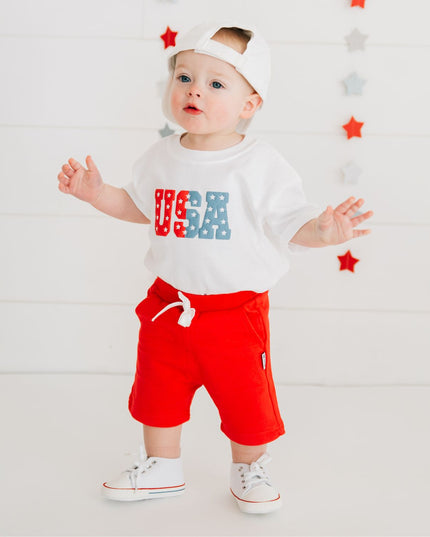 Baby wearing white romper with USA graphic