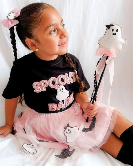 Girl wearing black t-shirt with spooky babe and ghost patch and holding ghost wand