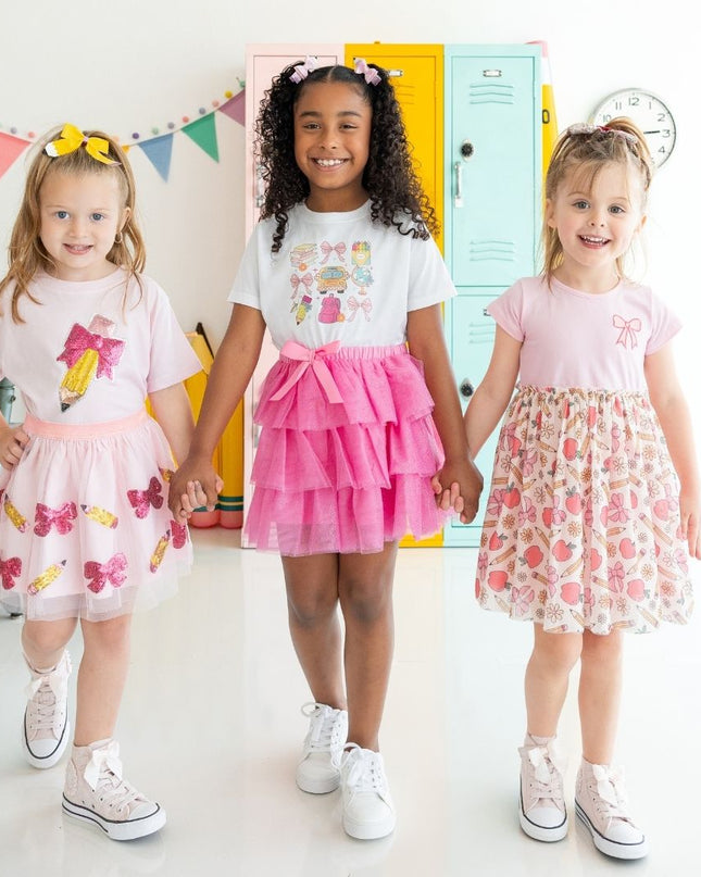 Three girls wearing coordinating pink back to school outfits