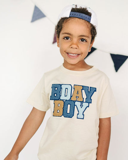 Boy wearing a 'BDAY BOY' patch t-shirt