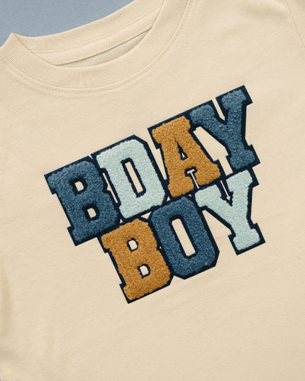 Beige t-shirt with 'BDAY BOY' patch  in colorful letters