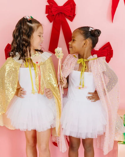 girls wearing capes and holding gingerbread and reindeer wands