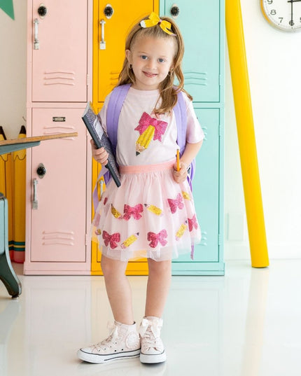 Girl wearing Pencil Bow Sequin Patch Short Sleeve Pink T-Shirt standing in front of lockers