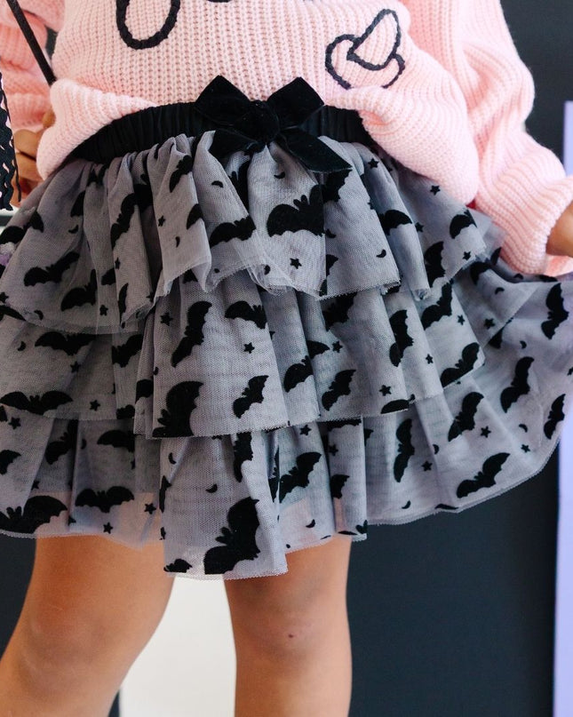 Girl wearing Dark grey tulle tutu with black velvet bats, stars and moons