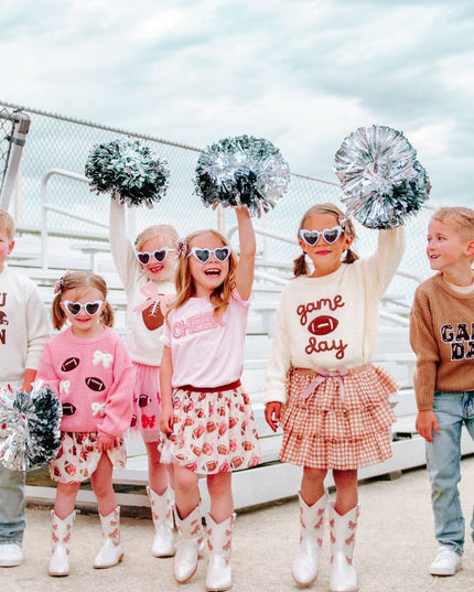 kids dressed in festive game day outfits on bleachers