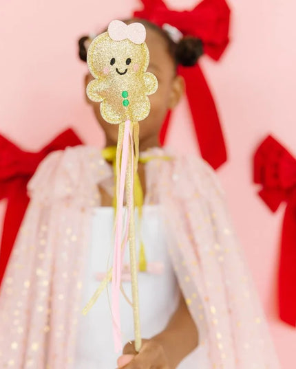 Girl holding gold gingerbread Christmas wand