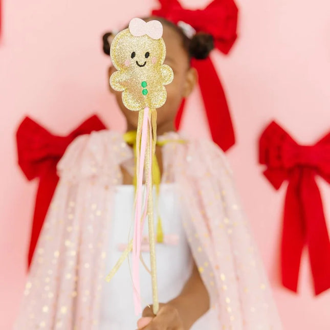 Girl holding gold gingerbread Christmas wand