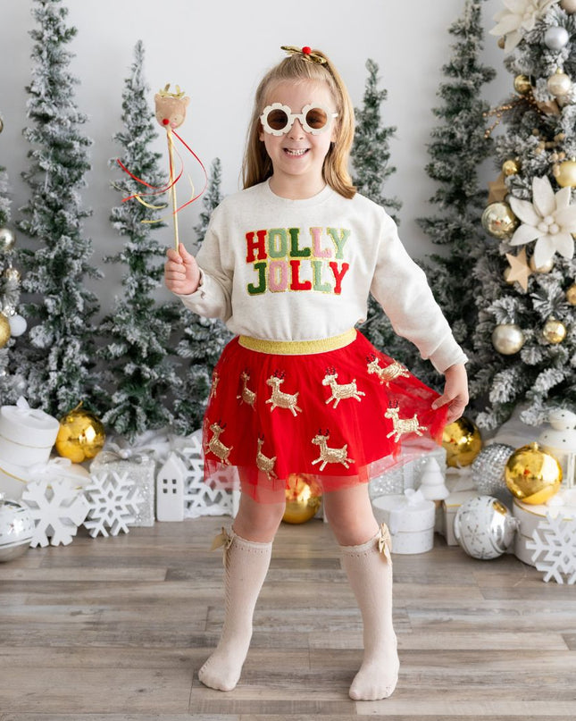 Girl wearing holly jolly Christmas sweatshirt, red reindeer tutu and holding a reindeer wand