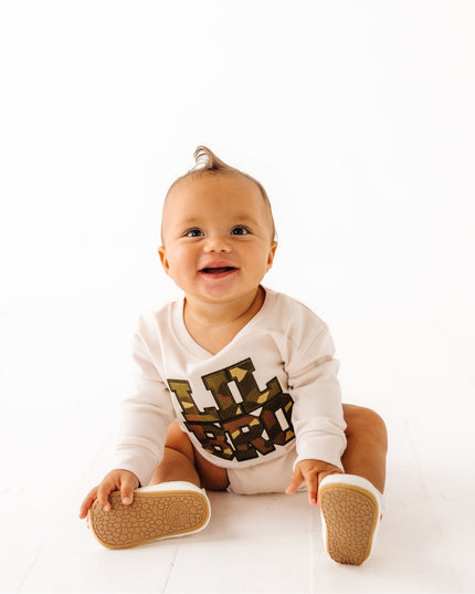 Baby wearing romper with camouflage Lil Bro Patch design