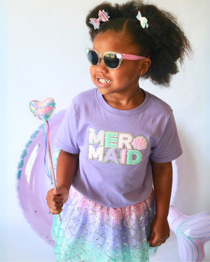 Girl wearing mermaid inspired outfit holding wand