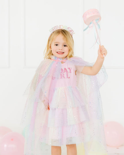 Girl wearing pastel cape holding a wand