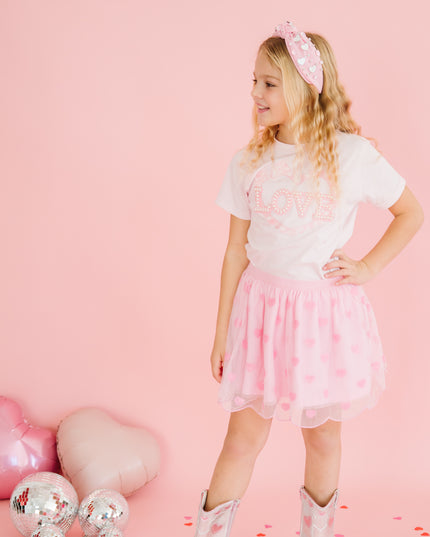 Girl wearing pink tutu with sequin hearts and love shirt