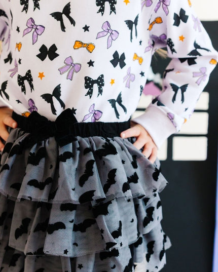 Girl wearing Dark grey tulle tutu with black velvet bats, stars and moons