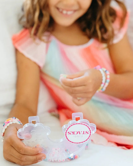 Girl playing with Rainbow shaped bead kit with colorful beads
