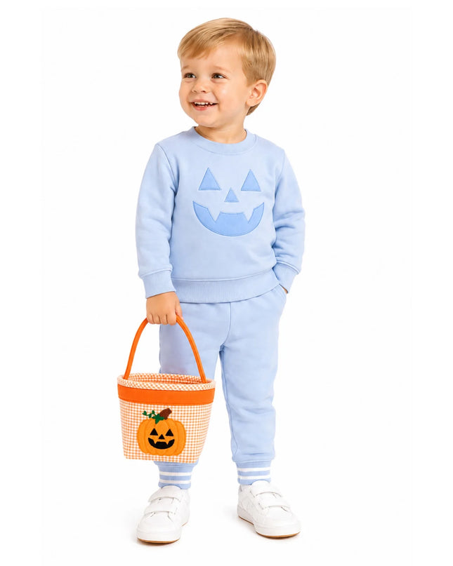 A young boy wearing a blue pumpkin outfit holding an orange and white gingham pumpkin tote
