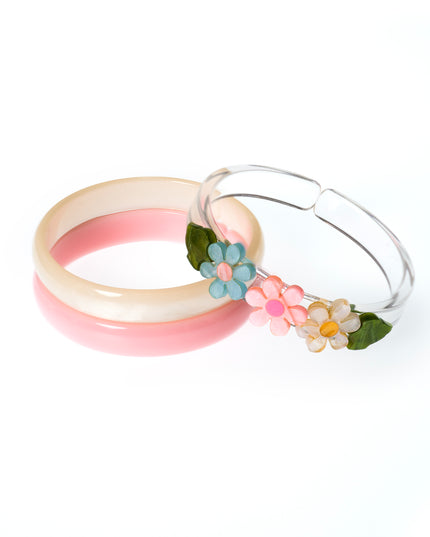 Set of bracelets featuring a pink bangle, cream bangle and clear bangles with pastel flowers. 