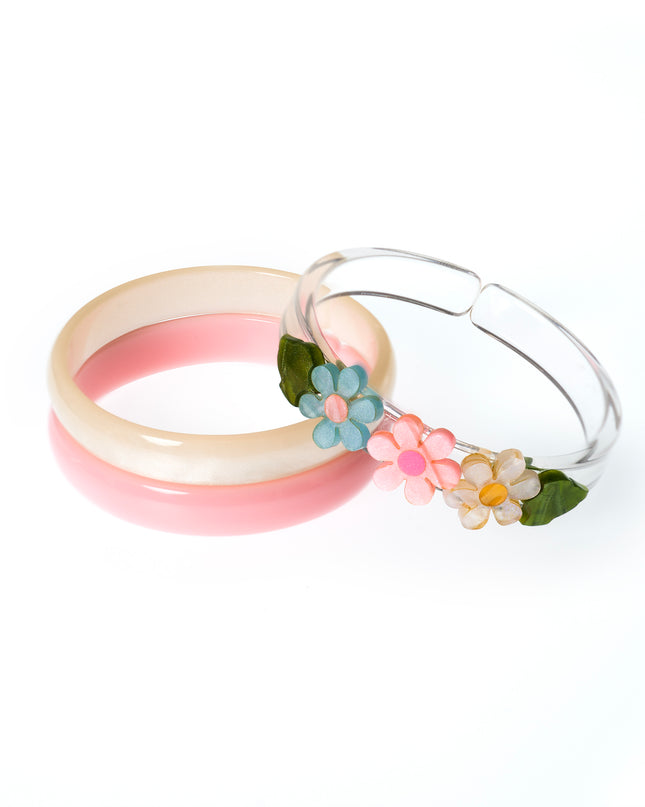 Set of bracelets featuring a pink bangle, cream bangle and clear bangles with pastel flowers. 