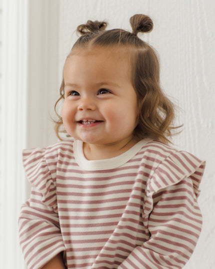 Little girl wearing mauve and white striped outfit