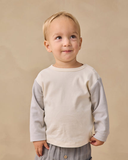 Boy wearing Long sleeve children's white raglan tee with grey sleeves and grey pants