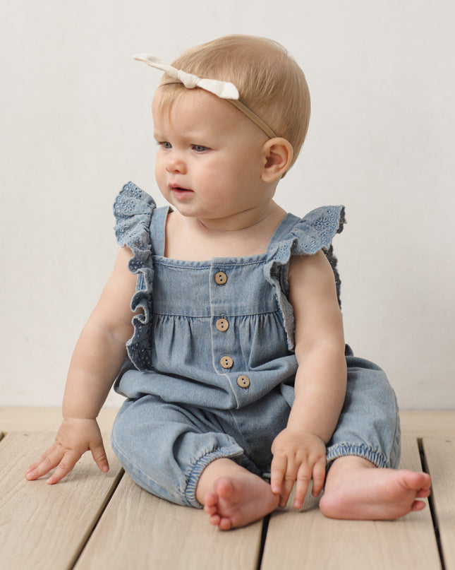 Baby wearing Denim romper with button and ruffle sleeves