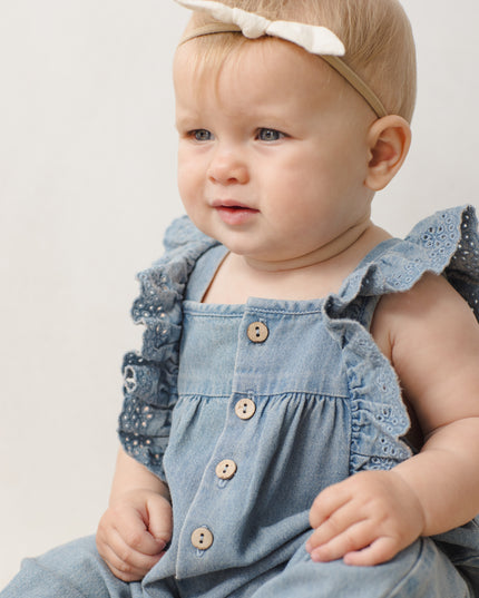 Baby wearing Denim romper with button and ruffle sleeves