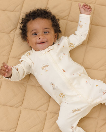 Baby wearing Longsleeve footie pajamas with a carnival print