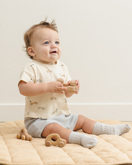 Baby wearing car shirt and light blue shorts