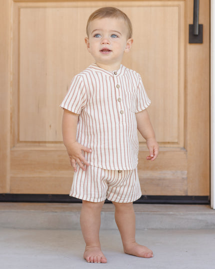 Boy wearing red and white striped shorts and shirt with buttons