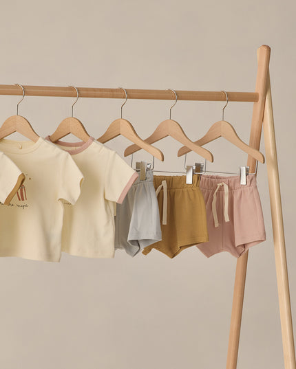 Shirts and shorts hanging on clothing rack