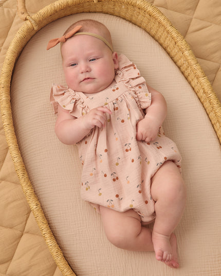 Baby wearing Blush romper with cherry print
