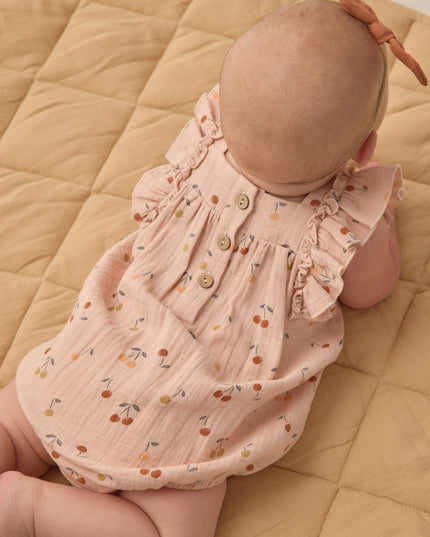 Baby wearing Blush romper with cherry print