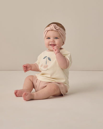 Baby wearing t-shirt with cherry design that says stay sweet