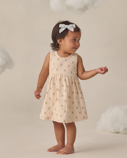 Girl wearing cream colored dress with delicate floral print