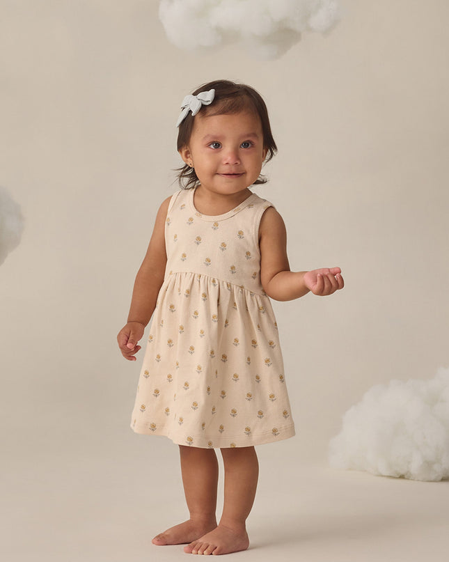 Girl wearing cream colored dress with delicate floral print